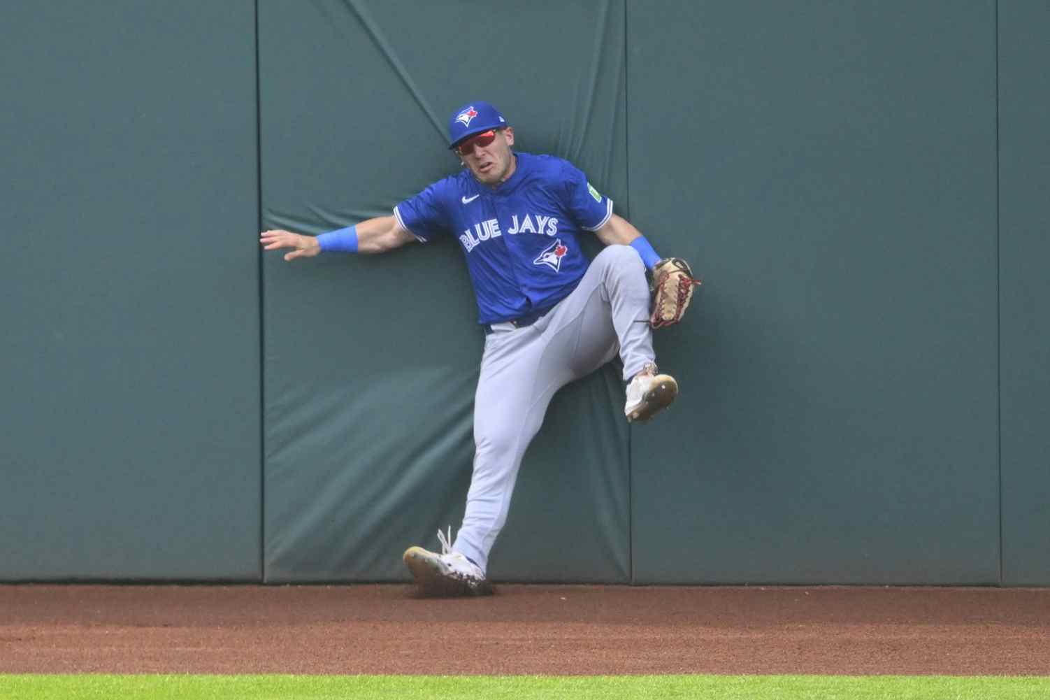 Toronto Blue Jays left fielder Daulton Varsho (25) hits the wall after making a catch on the warning track in the second inning against the Cleveland Guardians at Progressive Field.
