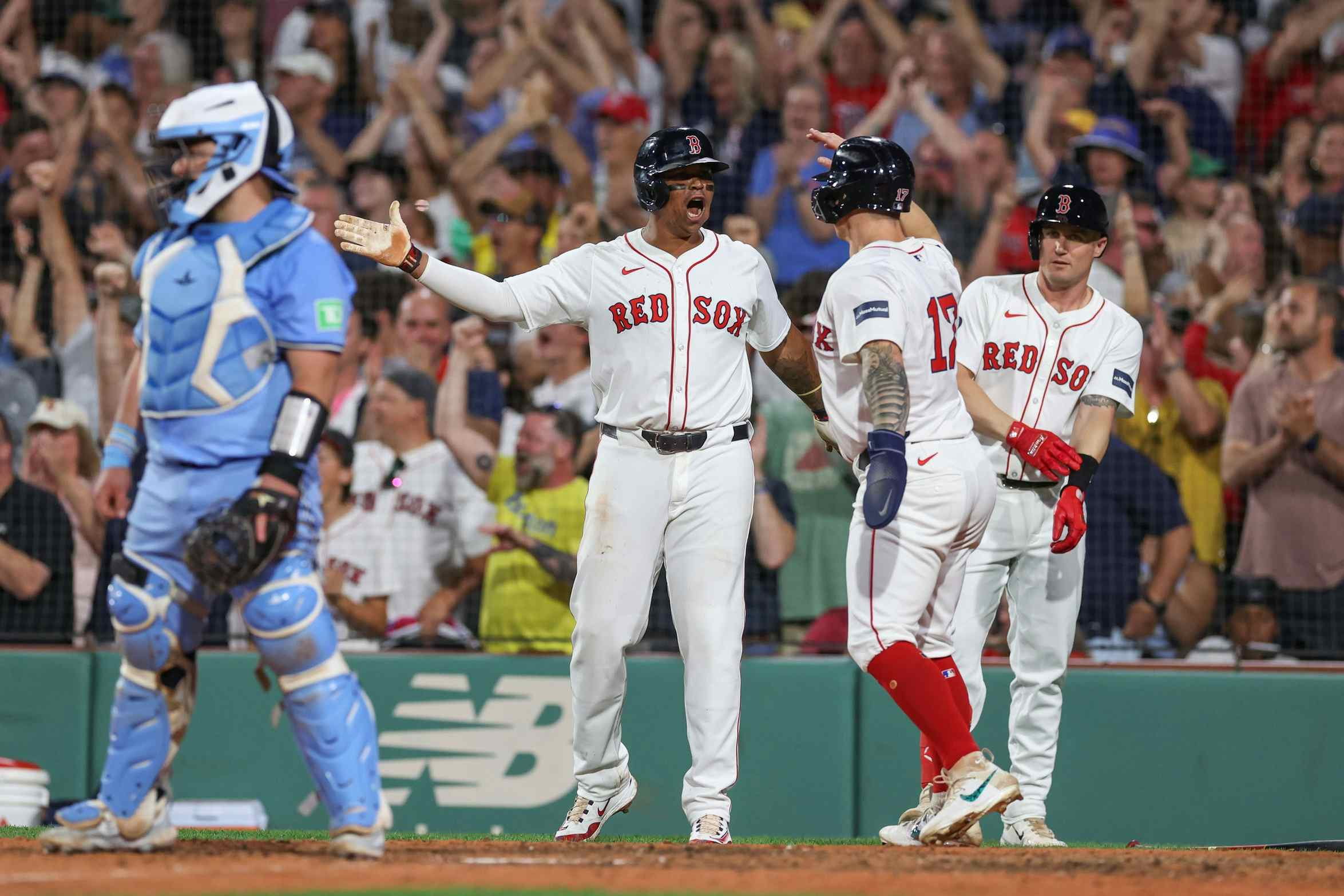 Boston Red Sox third baseman Rafael Devers (11) celebrates with Boston Red Sox right fielder Tyler O'Neill (17) after scoring during the eighth inning against the Toronto Blue Jays at Fenway Park.