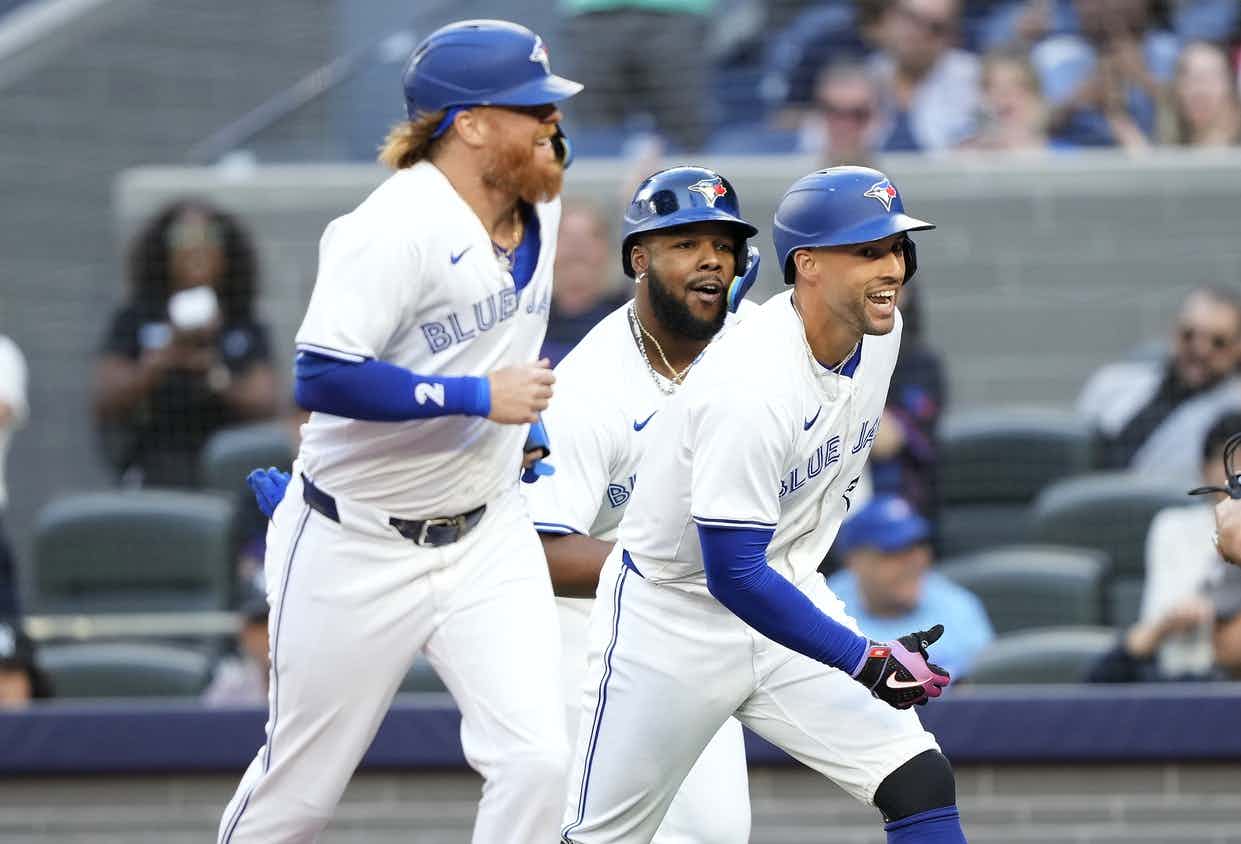 Toronto Blue Jays right fielder George Springer (right), designated hitter Justin Turner (2) and first baseman Vladimir Guerrero Jr. (center) celebrate at home plate after they scored on Springer's home run against the New York Yankees during the first inning at Rogers Centre.