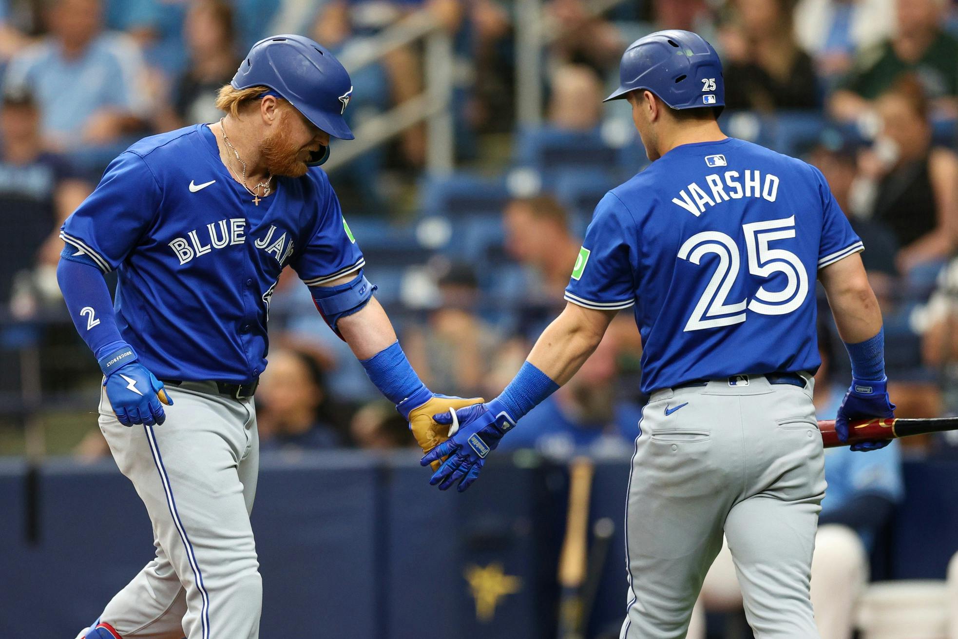 Toronto Blue Jays third baseman Justin Turner (2) is congratulated by center fielder Daulton Varsho (25) after hitting a home runagainst the Tampa Bay Rays in the fifth inning at Tropicana Field.