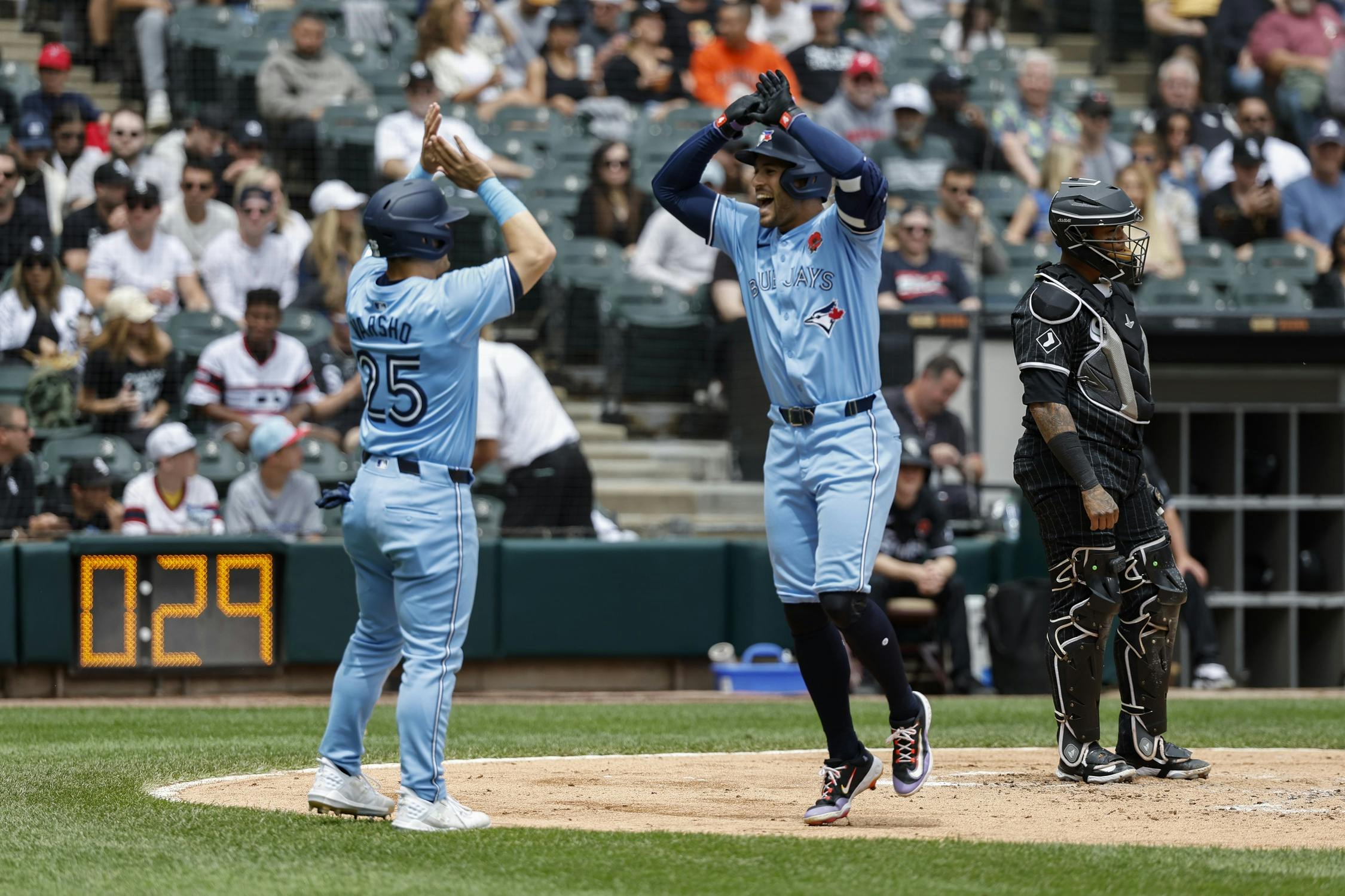 Toronto Blue Jays outfielder George Springer (4) celebrates with outfielder Daulton Varsho (25) after hitting a two-run home run against the Chicago White Sox during the second inning at Guaranteed Rate Field.