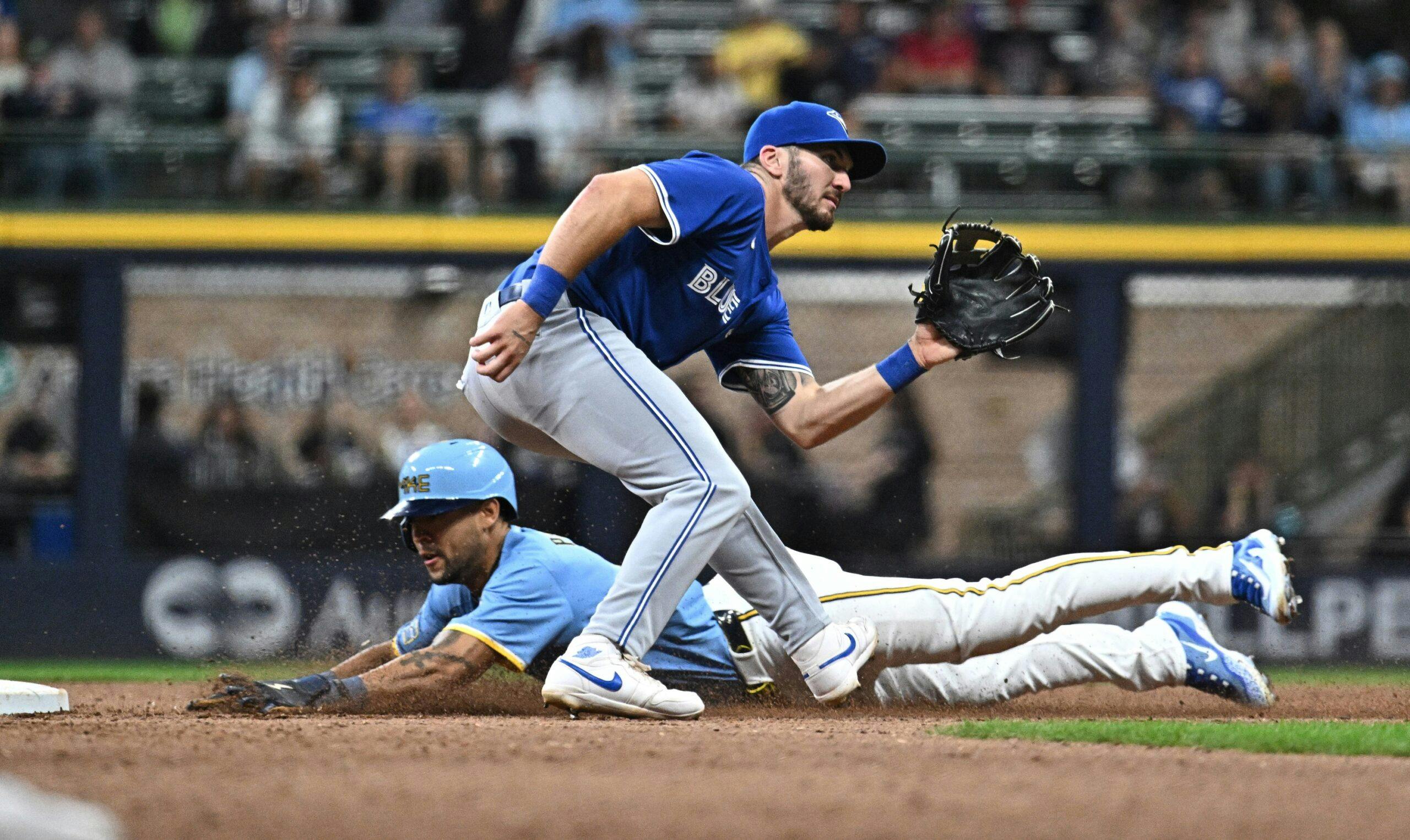 Milwaukee Brewers outfielder Blake Perkins (16) steals second base ahead of the tag by Toronto Blue Jays second baseman Spencer Horwitz (48) in the sixth inning at American Family Field
