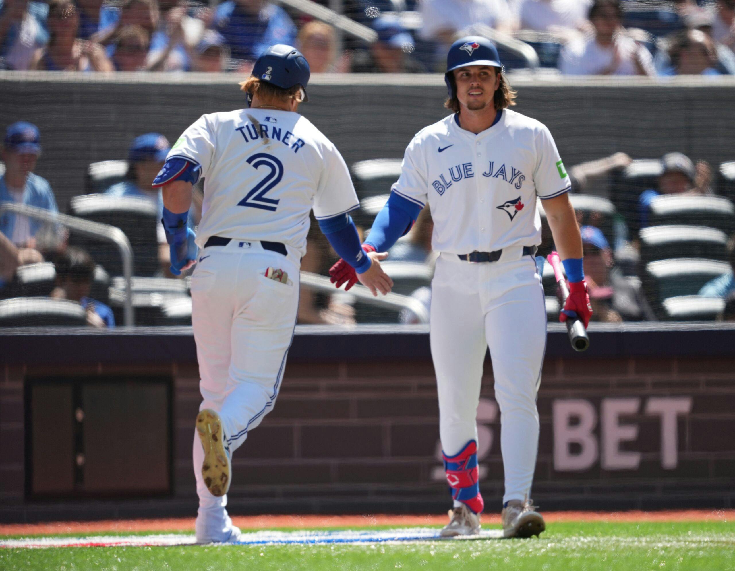 Toronto Blue Jays designated hitter Justin Turner (2) scores a run and celebrates with Toronto Blue Jays third baseman Addison Barger (47) against the Cleveland Guardians during the second inning at Rogers Centre.
