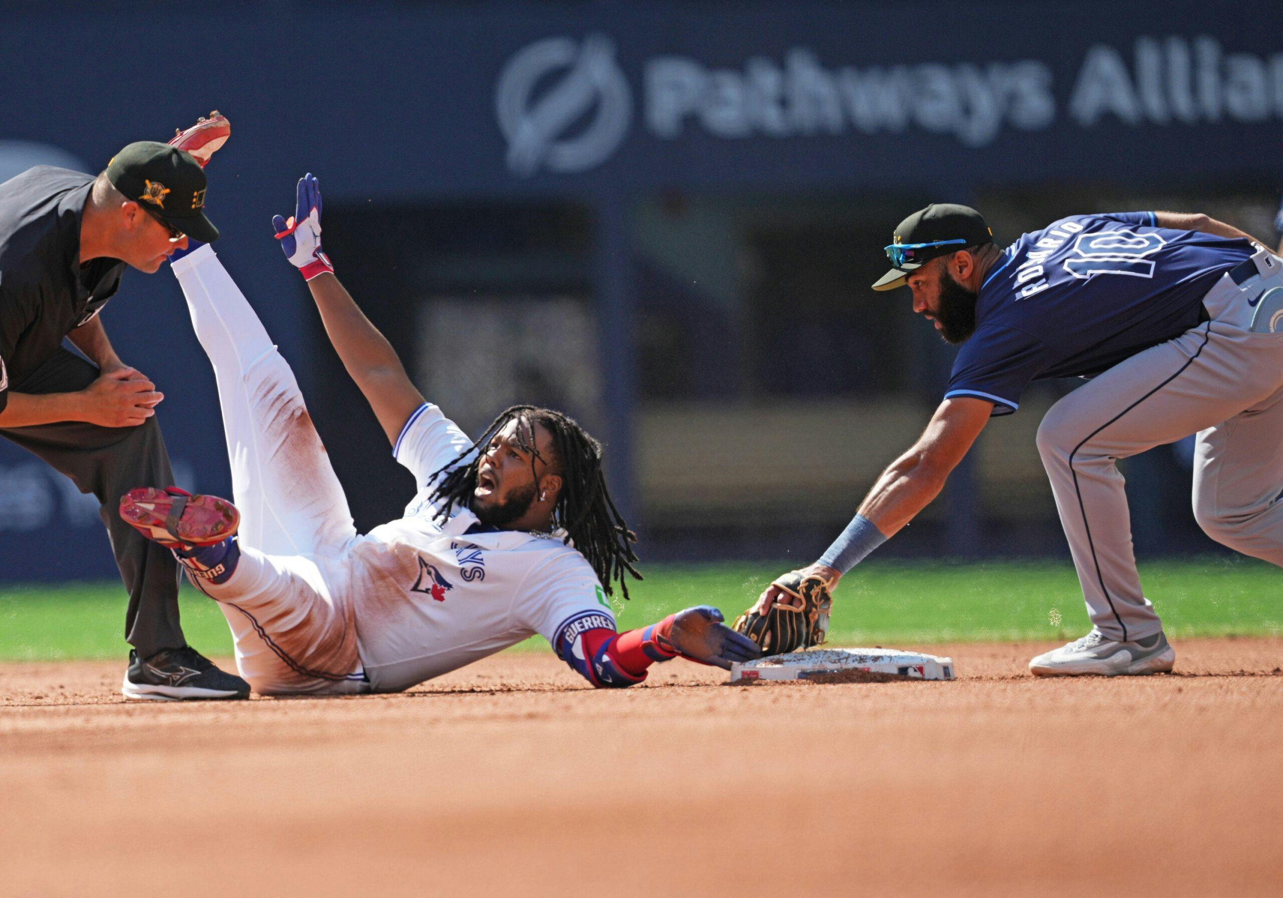 Toronto Blue Jays first base Vladimir Guerrero Jr. (27) is safe at second base ahead of the tag from Tampa Bay Rays second baseman Amed Rosario (10) after hitting a double during the fourth inning at Rogers Centre.
