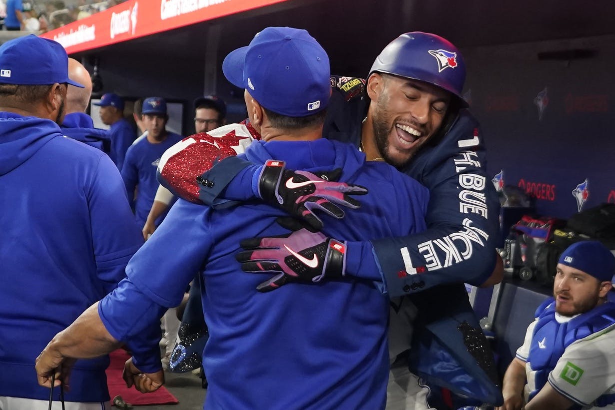 Toronto Blue Jays designated hitter George Springer (4) celebrates his two-run home run against the Cincinnati Reds in the dug out during the second inning at Rogers Centre