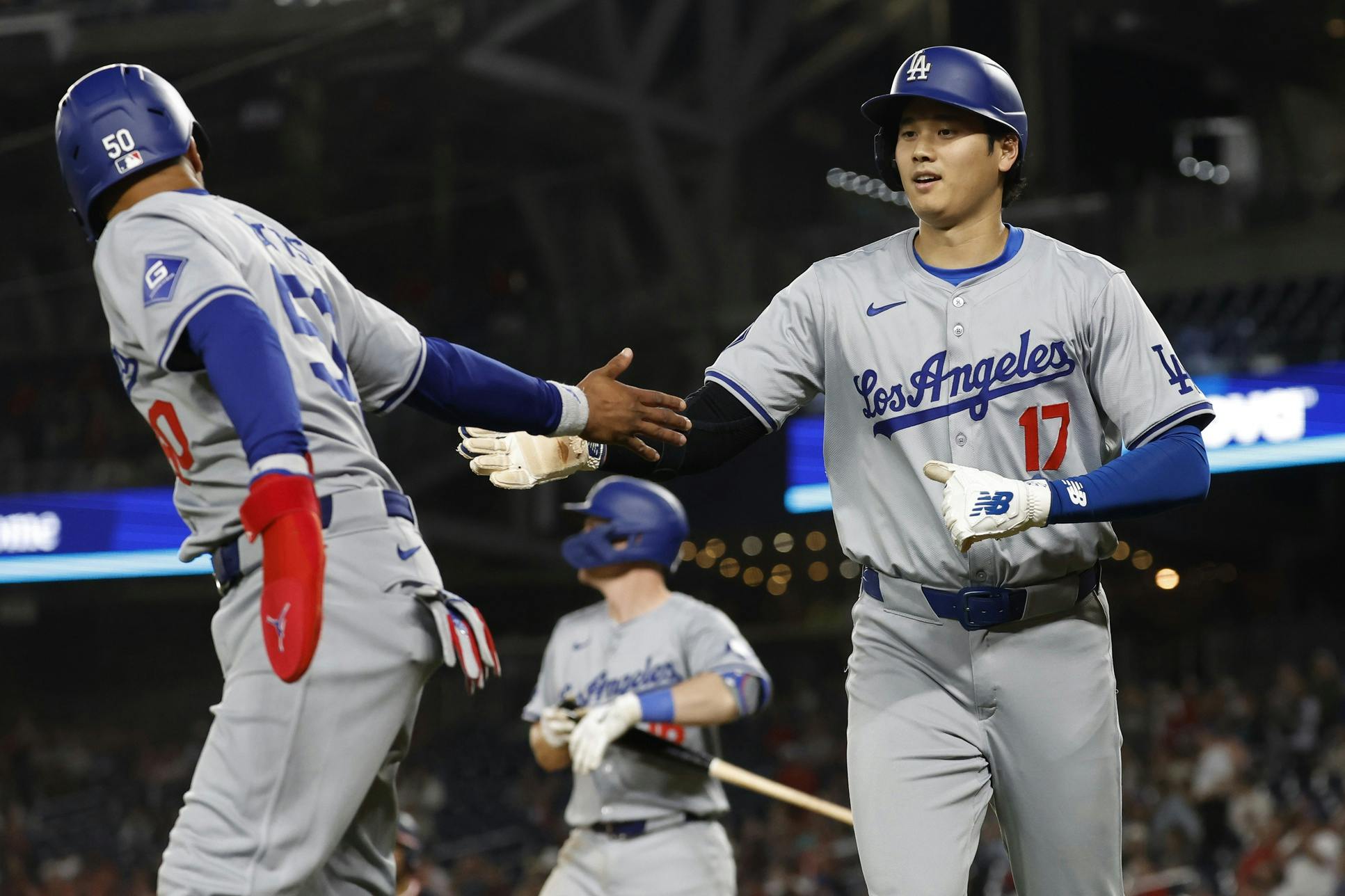 Los Angeles Dodgers shortstop Mookie Betts (50) and Dodgers designated hitter Shohei Ohtani (17) celebrate after scoring runs on a single by Dodgers first baseman Freddie Freeman (not pictured) against the Washington Nationals during the ninth inning at Nationals Park.