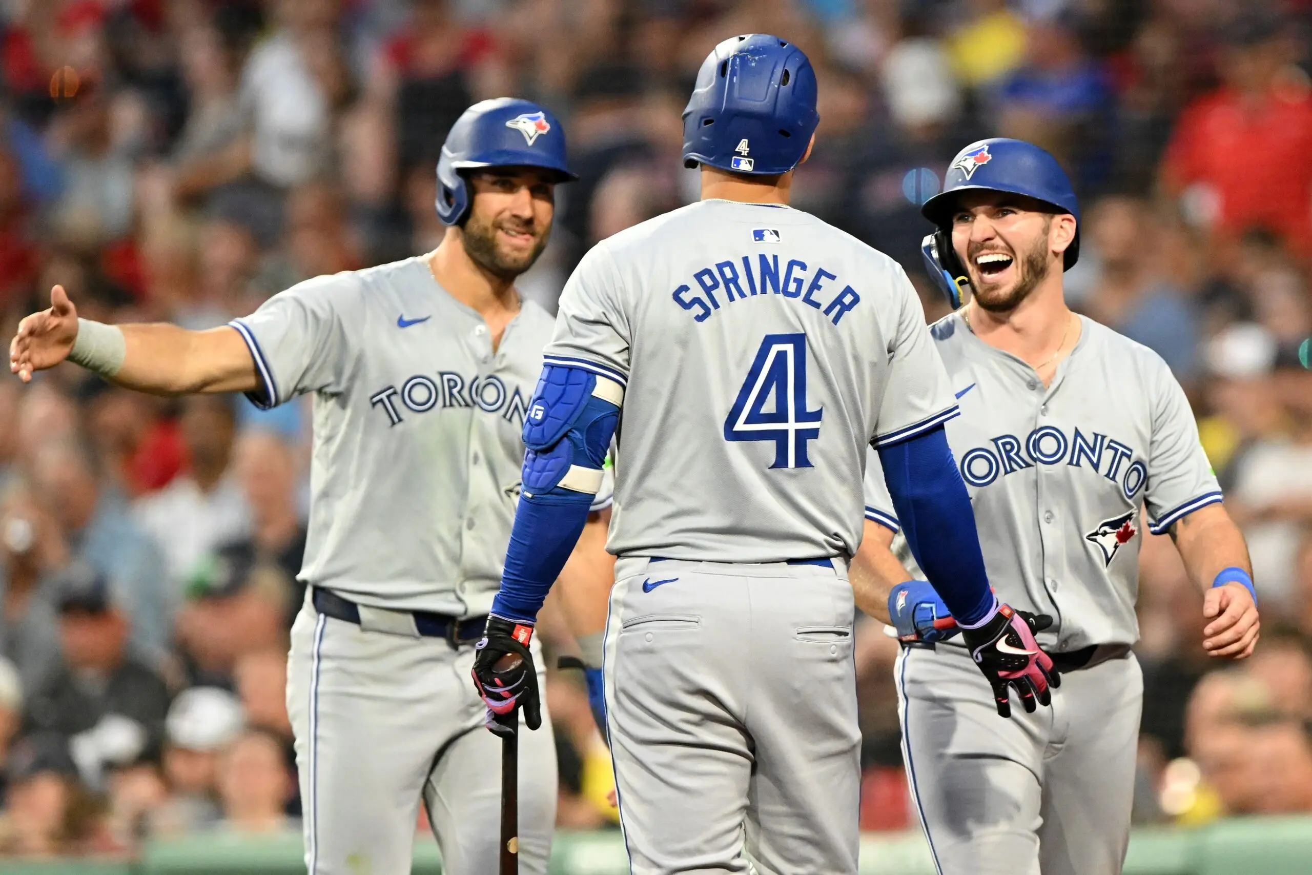 Toronto Blue Jays second baseman Spencer Horwitz (48) and center fielder Kevin Kiermaier (39) celebrate with right fielder George Springer (4) after scoring runs against the Boston Red Sox during the fourth inning at Fenway Park