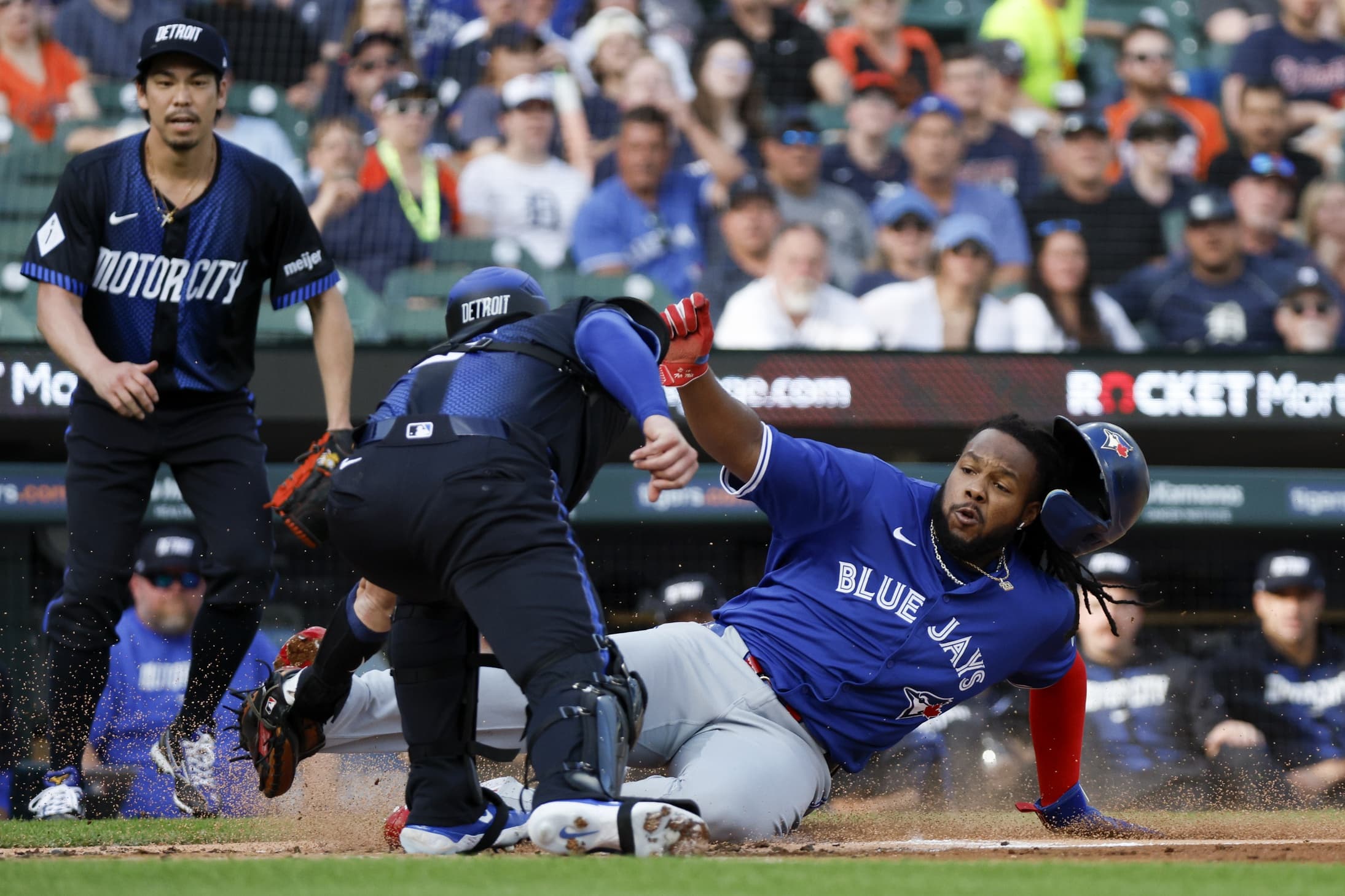 Toronto Blue Jays first baseman Vladimir Guerrero Jr. (27) slides into home plate and is tagged out by Detroit Tigers catcher Carson Kelly (15) in the first inning against the Detroit Tigers at Comerica Park.