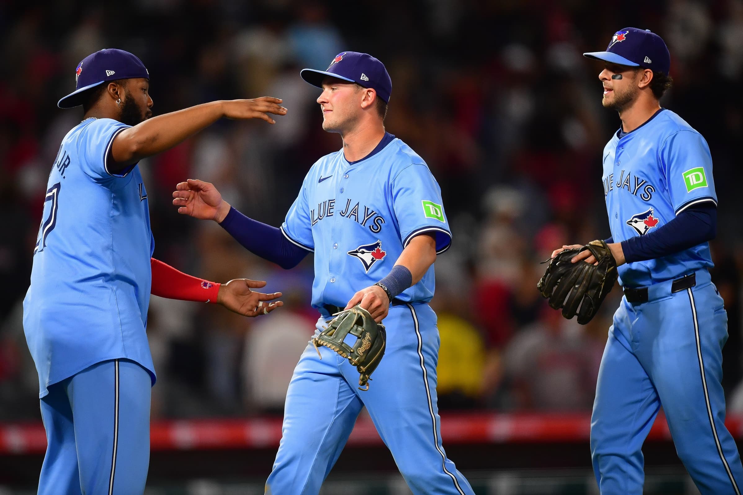 Toronto Blue Jays designated hitter Vladimir Guerrero Jr. (27) second baseman Will Wagner (7) and left fielder Joey Loperfido (9) celebrate the victory against the Los Angeles Angels at Angel Stadium.