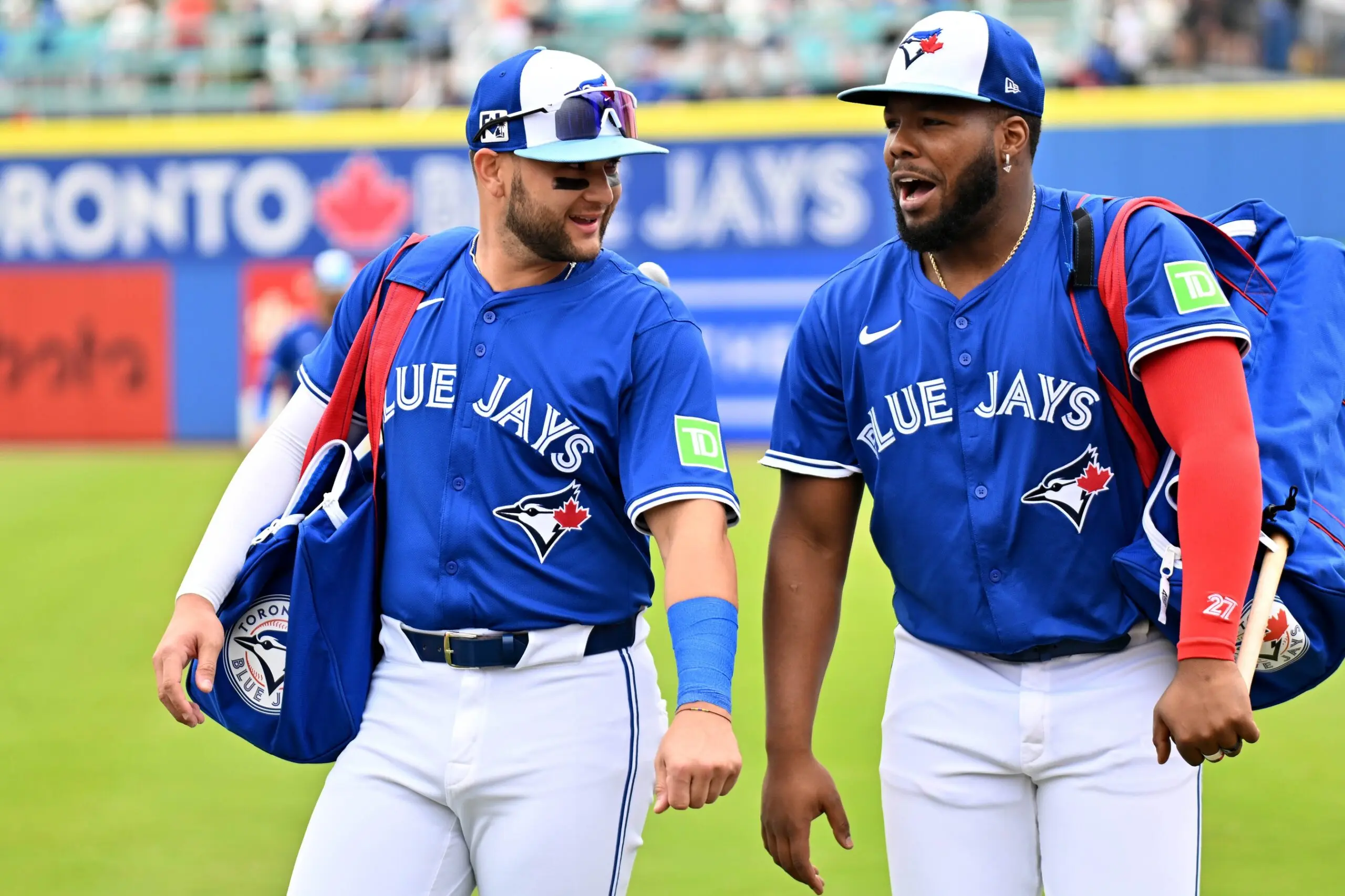 Toronto Blue Jays shortstop Bo Bichette (11) and designated hitter Vladimir Guerrero Jr. (27) walk towards the dugout before a spring training game against the St. Louis Cardinals at TD Ballpark.