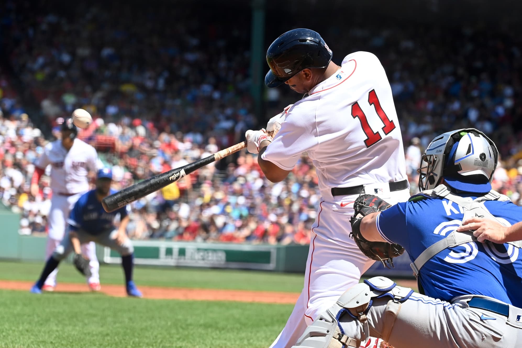 Boston Red Sox third baseman Rafael Devers (11) hits a double against the Toronto Blue Jays during the first inning at Fenway Park.