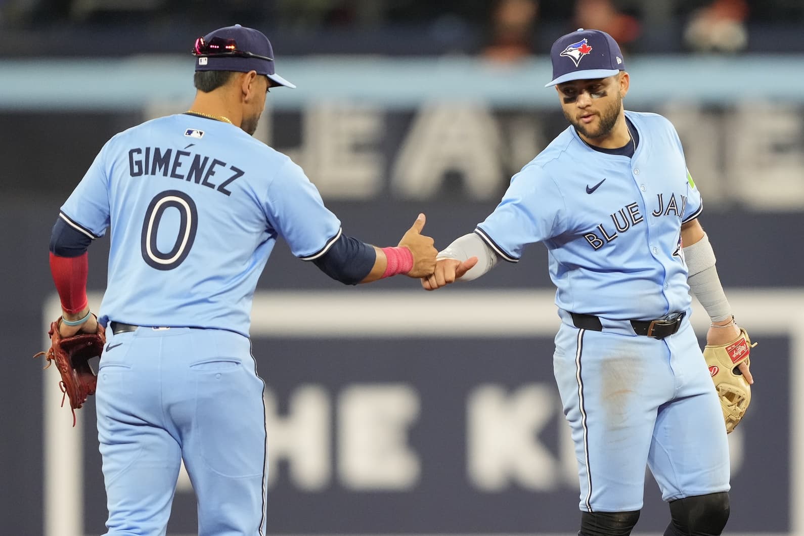 Toronto Blue Jays shortstop Bo Bichette (11) congratulates second baseman Andres Gimenez (0) after making an out against the Baltimore Orioles during the ninth inning at Rogers Centre
