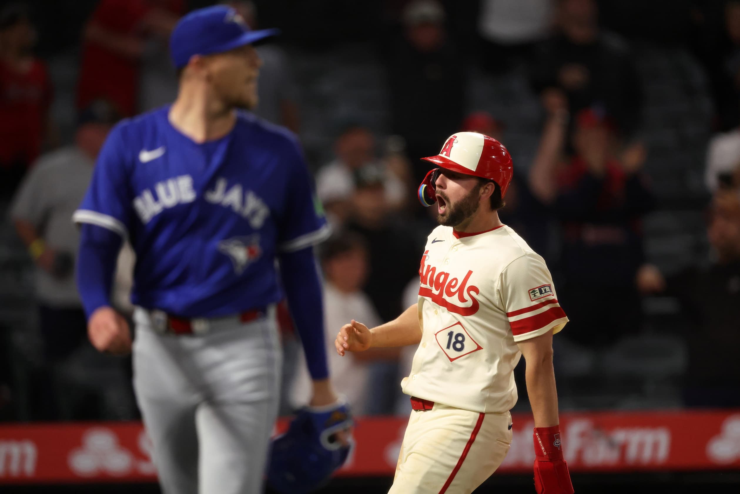 Los Angeles Angels first baseman Nolan Schanuel (18) celebrates after scoring the winning run on a double by right fielder Jorge Soler (12, not pictured) as Toronto Blue Jays relief pitcher Jeff Hoffman (23)walks off the field during the ninth inning at Angel Stadium.