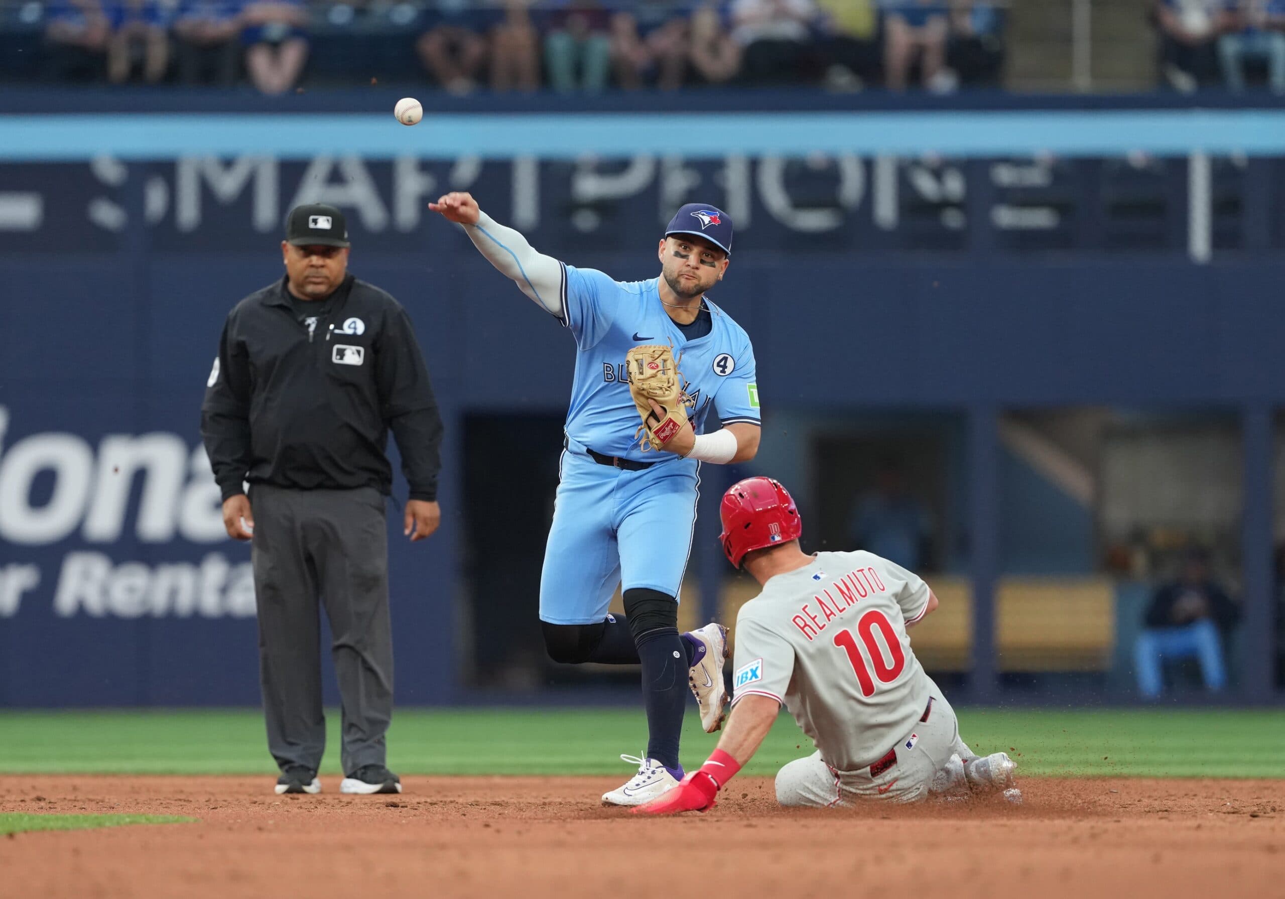 Toronto Blue Jays shortstop Bo Bichette (11) tags out Philadelphia Phillies catcher J.T. Realmuto (10) at second base during the third inning at Rogers Centre.