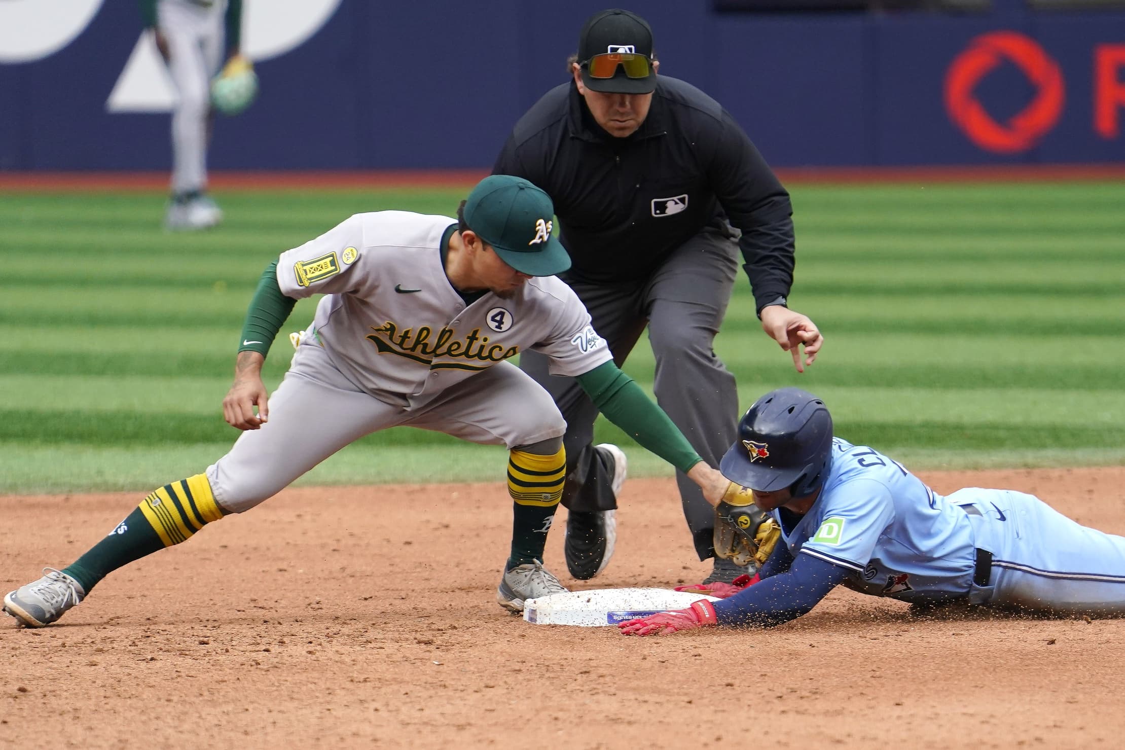 Toronto Blue Jays first baseman Ernie Clement (22) beats the tag from Athletics second baseman Luis Urias (17) to slide safely to second base on a double during the eighth inning at Rogers Centre.