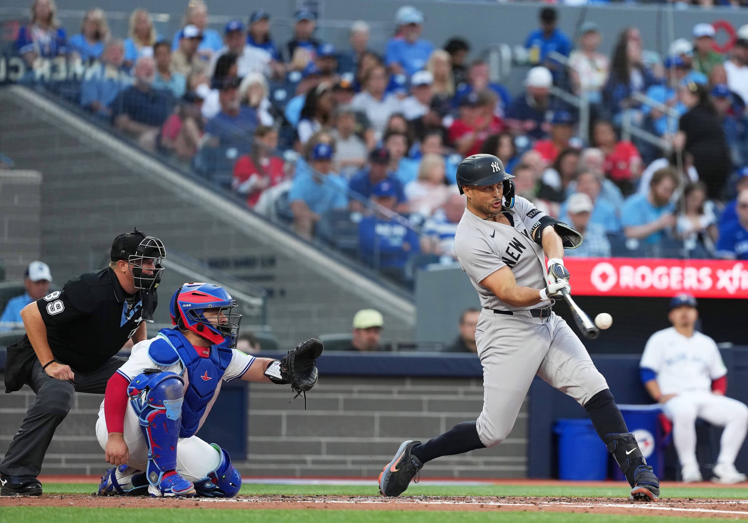 New York Yankees designated hitter Giancarlo Stanton (27) hits a home run against the Toronto Blue Jays during the fourth inning at Rogers Centre.