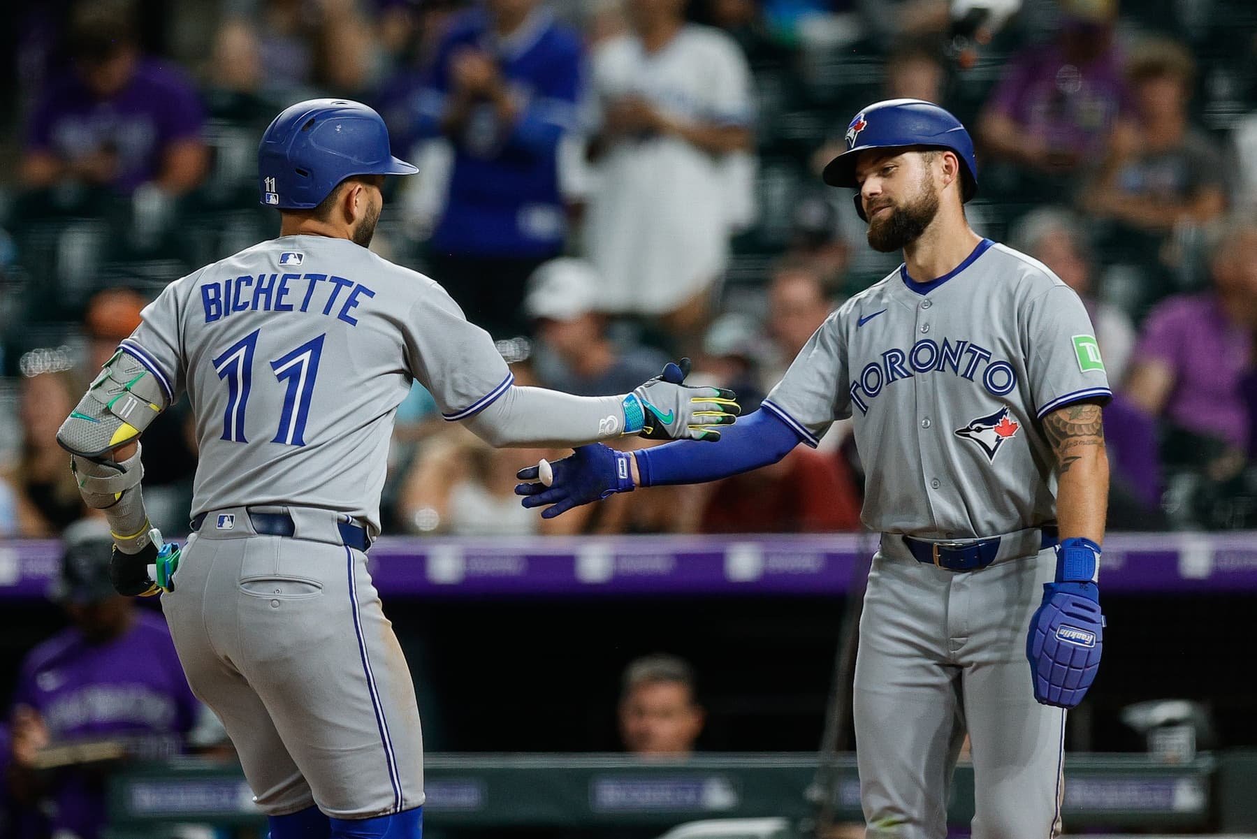 Toronto Blue Jays designated hitter Bo Bichette (11) celebrates his three run home run with right fielder Nathan Lukes (38) in the seventh inning against the Colorado Rockies at Coors Field.