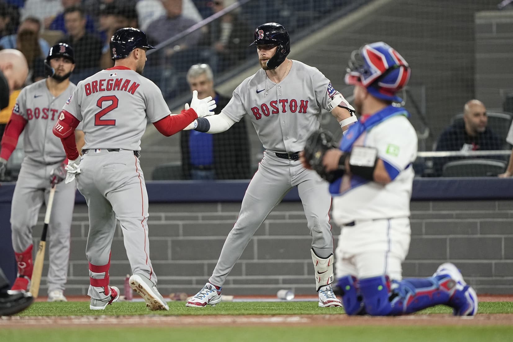 Boston Red Sox shortstop Trevor Story (10) congratulates third baseman Alex Bregman (2) on his solo home run against the Toronto Blue Jays during the first inning at Rogers Centre