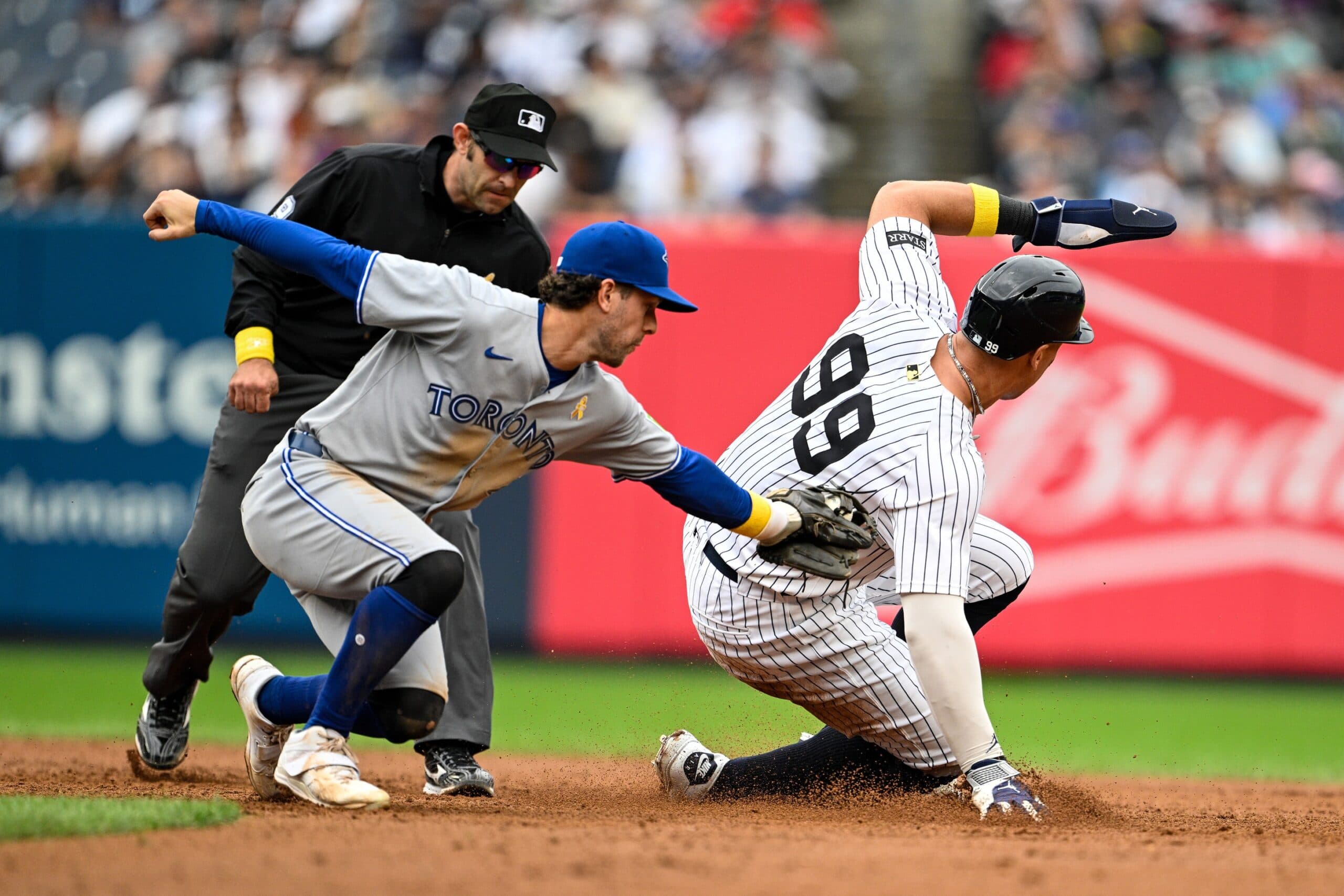 New York Yankees right fielder Aaron Judge (99) slides to steal 2nd base against Toronto Blue Jays third baseman Ernie Clement (22) during the eighth inning at Yankee Stadium.